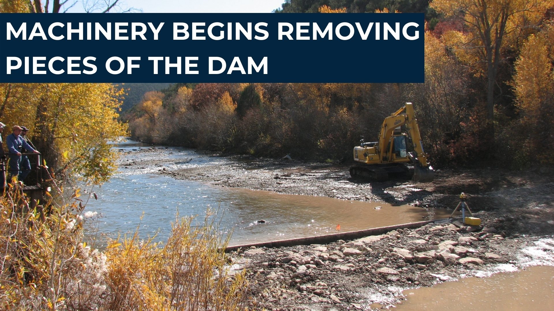 Machinery begins removing pieces of the dam